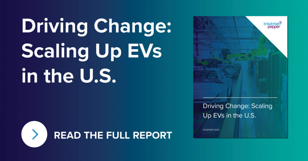 white text "Driving Change: Scaling Up EVs in the U.S." with arrow in white circle next to text "Read the Full Report" on left side and an image of the cover that includes troutman Pepper logo in top right, title "Driving Change: Scaling Up EVs in the U.S." with image of blue overtoned image of a car manufacturing assembly line